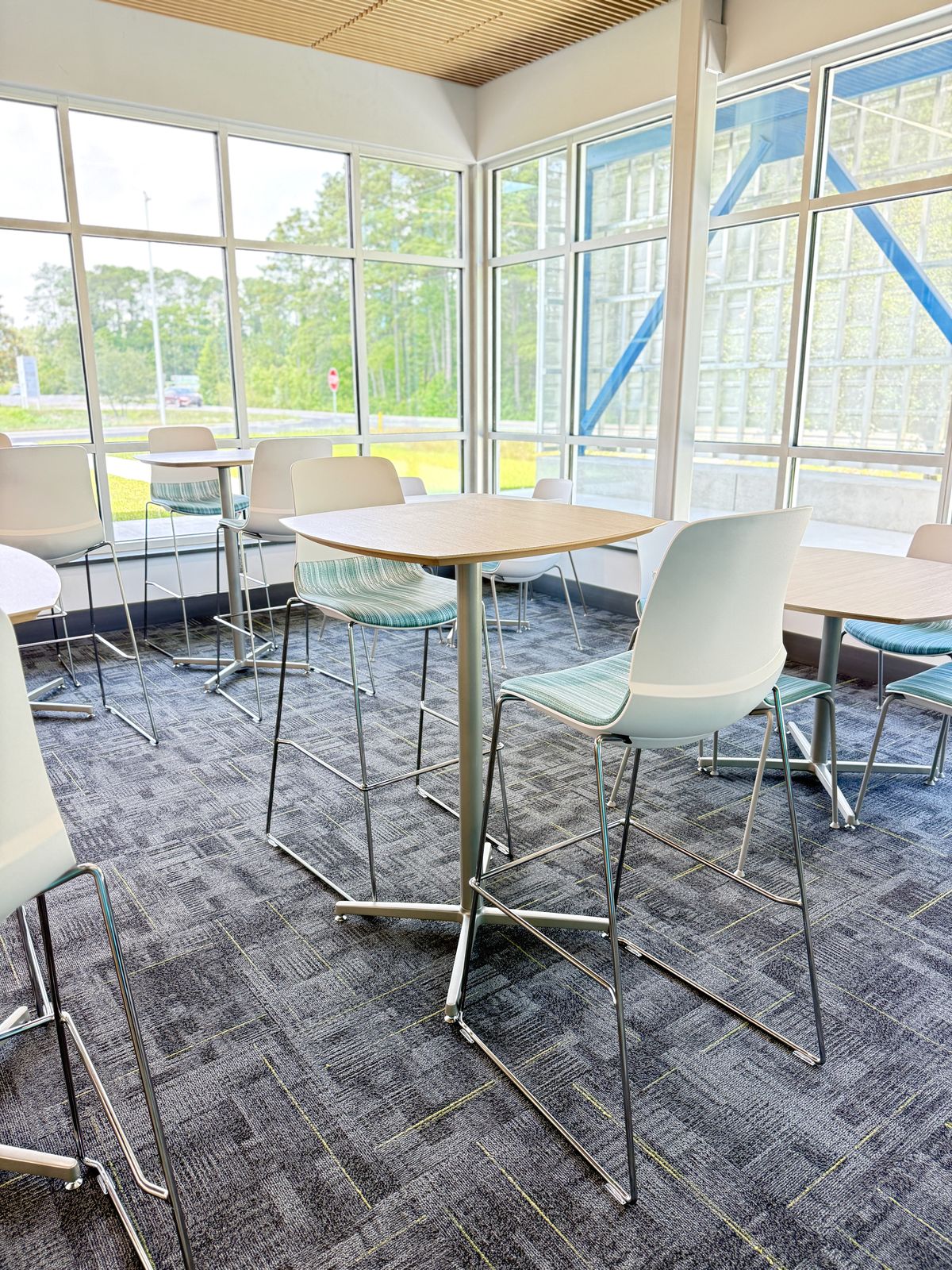 Bar-height tables and stools beside tall windows