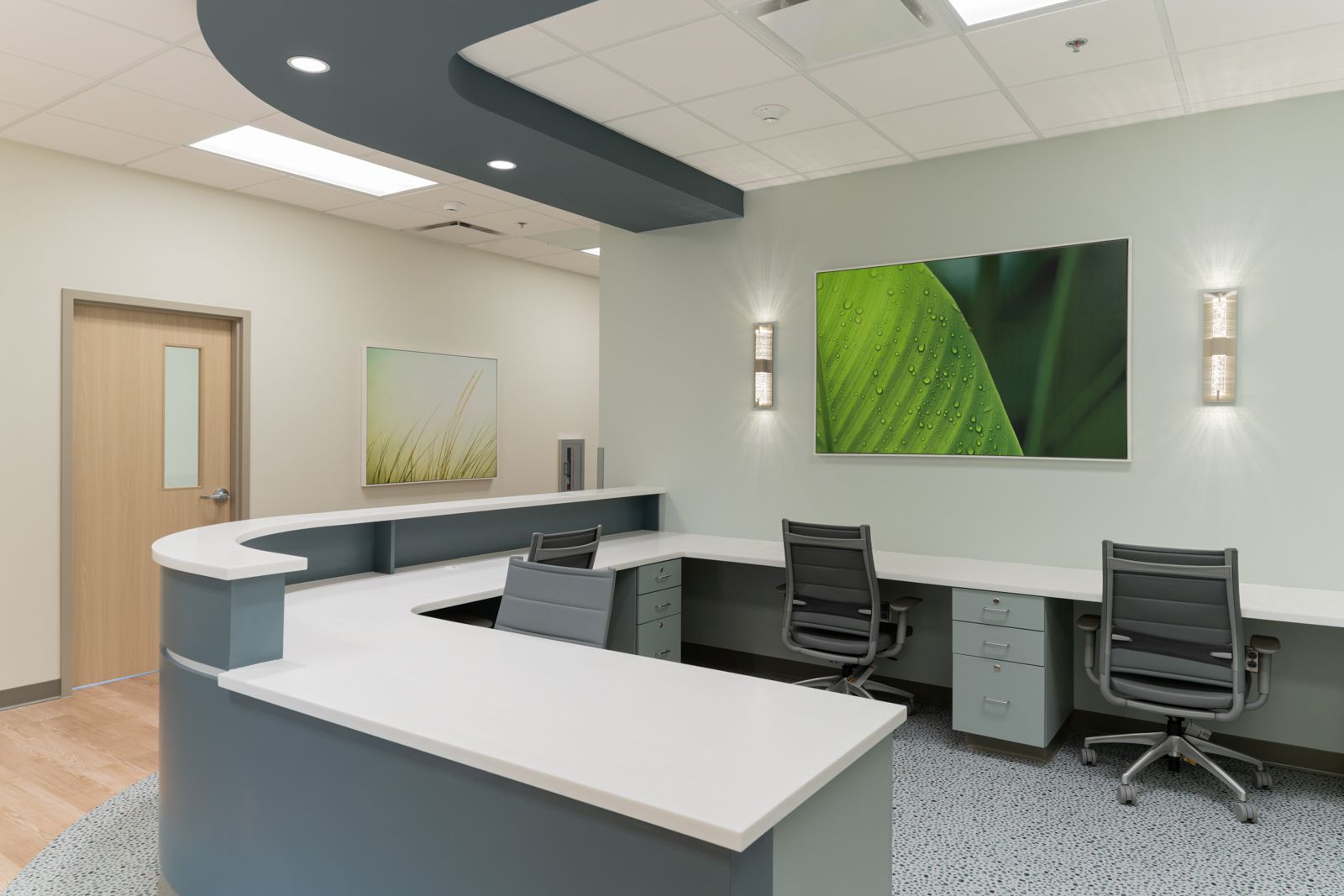 Staff workstation with sconces flanking backlit art